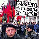«Русский марш» в 2012 году в Москве, антисемитский плакат на фоне флагов с «коловратом»