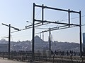 Деталь разрыва в контактной сети для трамваев между одним подъёмником (слева) и неподвижной частью моста. Мечеть Сулеймание находится на заднем фоне.