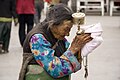 Пожилая тибетская женщина с молитвенным барабаном