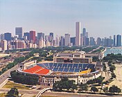 An aerial view of Soldier Field with the Chicago skyline in the background