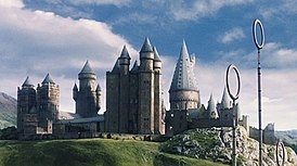 Эмблема Хогвартса (сверху) и сам Хогвартс, изображённый в фильме «Гарри Поттер и философский камень» (2001) (снизу)