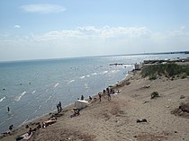 Общедоступный государственный пляж и прибрежный берег водохранилища Капшагай. На дальнем плане пляжа видны частные контейнеры, которые незаконно установлены в водоохранной зоне.