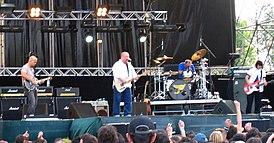 Выступление на фестивале Heineken Jammin' Festival[en] в 2004 году. Слева направо: Джоуи Сантьяго, Блэк Фрэнсис, Дэвид Ловеринг, Ким Дил