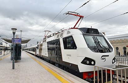 Электровоз AZ4A-0002 с пассажирским поездом производства Alstom Transport на перроне вокзала