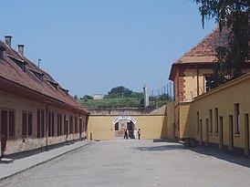Ворота в здании крепости с надписью «Труд освобождает» (нем. Arbeit macht frei)