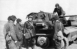 Группа танкистов у танка Tetrarch MkVII. 1942 год. Танкисты одеты в комбинезоны и шлемы довоенного образца; командир — в кожаную куртку с полным снаряжением поверх обмундирования.