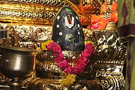 Шалаграм на алтаре, украшенный тилакой Вишну