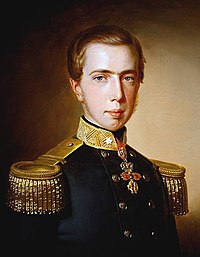 Half-length painted portrait of a young man with thin sideburns who is wearing a double-breasted black military tunic with large gold-braided epaulets and a medal on a ribbon about his neck
