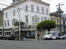 A color photo of a building with 'Haight' and 'Ashbury' signs on opposite sides of its corner