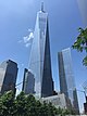 Distant ground-level view of a 108-story building with a black steel exterior and dark windows; the building has setbacks at several levels, and two large antennas rise above its roof.