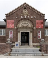 A short flight of stairs leads up to a red-brick civic building