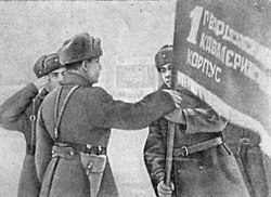Бригадный комиссар Смирнов вручает гвардейское Знамя командиру корпуса.