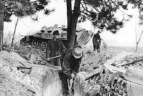 Солдаты зенитной батареи роют огневые позиции для зенитной установки. На заднем плане – бронетранспортёр Sd.Kfz. 251.