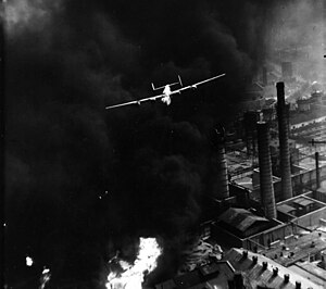 B-24, пилотируемый Робертом Стернфилсом, на фоне пожара в ходе операции «Tidal Wave».