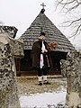 Человек в народном костюме перед церковью Святого Николая, Романовци (община Градишка)