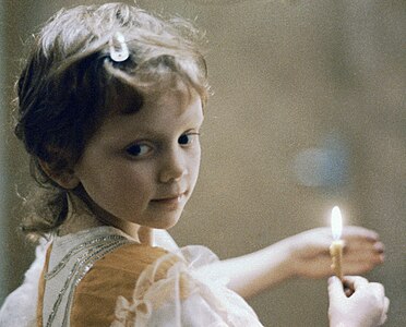 Девочка держит в руках свечу на рождественском вечере, 7 января 1995 года