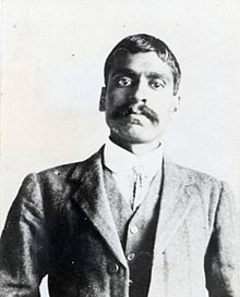 A Bengali hong man with full mustache dressed in dark suit