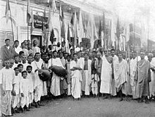 A group of India people with drums and flags in a semicircle