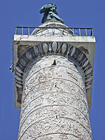 Oberes Ende der Trajanssäule. Das Kapitell ist der auskragende, rechteckige Stein mit der Metallbrüstung, unweit der Spitze.