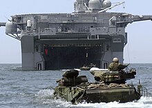 color photo of swimming AAVs approaching the well deck of an amphibious assault ship