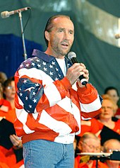 Lee Greenwood singing into a microphone