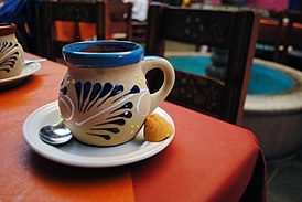 Кофе де олья в традиционной чашке с кусочком панелы.