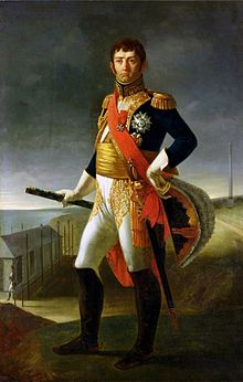 Full-length portrait of a frowning Soult in dark blue marshal’s uniform with one hand on his hip and the other holding a spyglass. His breeches are white with black knee boots and he has a gold sash around his waist.