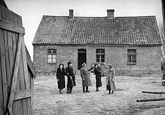Немцам-переселенцам показывают их новое жильё в Вартеланде, 1939 г.
