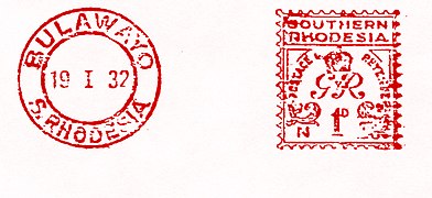 1932: 1 пенни, монограмма Георга V («GvR»), с надписью «Postage & Revenue» («Почтовый и гербовый сбор»). Слева: календарный штемпель Булавайо