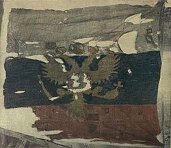 При внимательном рассмотрении изображения видно, что «древко», вернее, место крепления флага к подъемному тросу (и сам трос) расположены справа от флага.