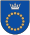 A coat of arms depicting a circle for which the boundary is itself made up of beige circles all under a silver crown on a blue background