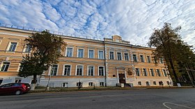 Панорамное изображение 2-этажного бежевого здания с подвальными помещениями.