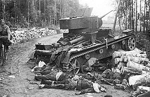 Финские солдаты проходят возле подбитого советского танка Т-26