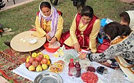 Женщины в национальных костюмах с кушаньями из граната.