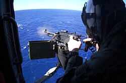 Бортовой стрелок палубного многоцелевого вертолёта SH-60 Seahawk отрабатывает стрельбу из 7,62-мм пулемётной установки M240 в ходе военных учений.